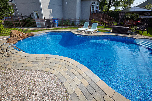 Organic shaped pool with natural rock feature.